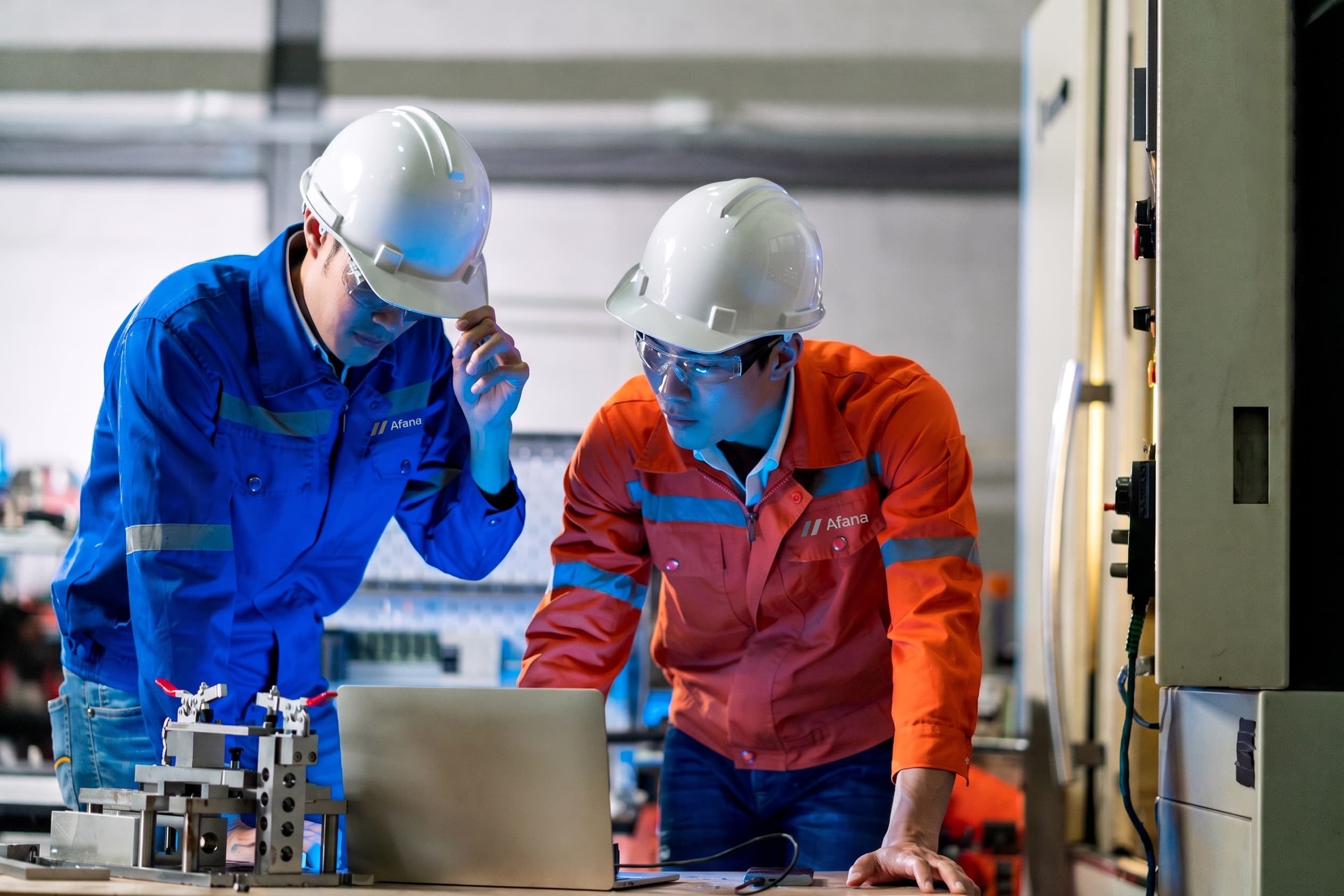 Dua teknisi Afana memeriksa panel kelistrikan di lingkungan industri